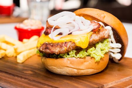 Pork burger with cheese, vegetable and served with friesの写真素材