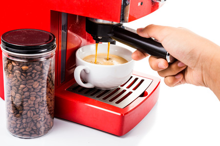 Hand operating red color coffee machine brewing espressoの写真素材