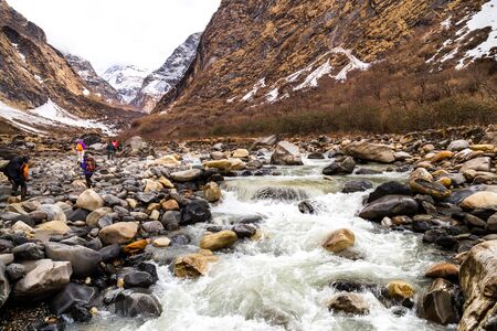 Group of people trekking on a valley towards the mountain summitの写真素材