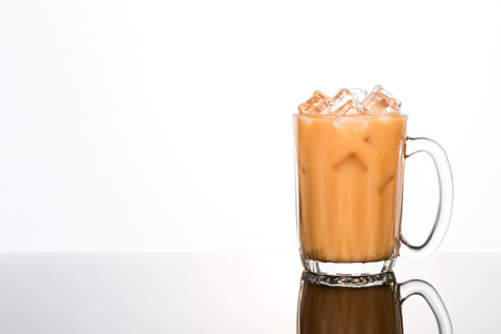 Refreshing ice cold tea with milk in transparent glassの写真素材