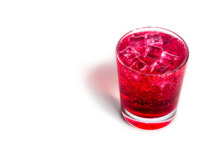 Refreshing red fizzy soft drink with ice in transparent glass.の写真素材