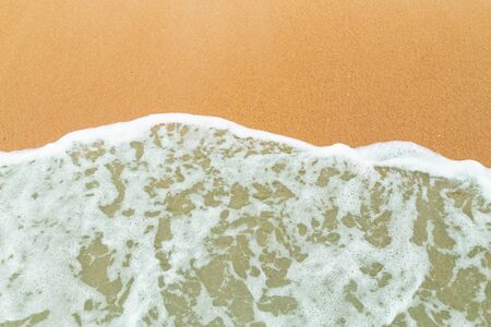 Calm sea waves breaking on sandy beach as background resources.