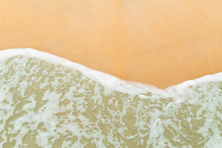 Calm sea waves breaking on sandy beach as background resources.