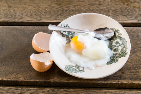 Asian Chinese half soft boiled egg served on old fashioned Oriental saucer