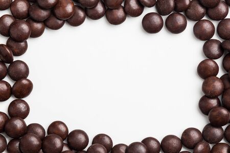 Frame of brown chocolate candy on white background with space for textの写真素材