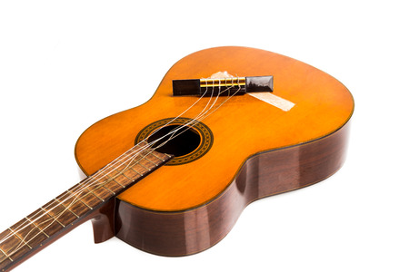 Broken brown classical guitar with detached bridge from body isolated in white background