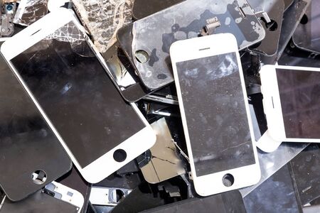 Stack and piles of damaged smart phone body and cracked LCD screen