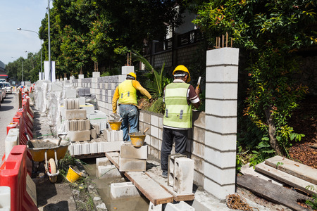Workers constructing building erecting noise barrier walls at busy highway road