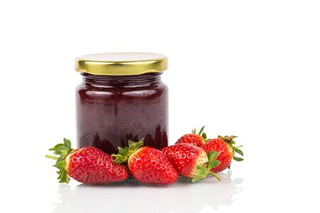 Organic strawberry jam in transparent glass jar on white background with fresh strawberries surroundingの写真素材