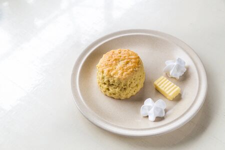 Simple and delicious English scones set with butter and cream with ambient light