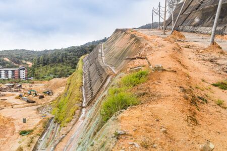 Slope and earth retention wall along hilly terrain in tropical environmentの写真素材