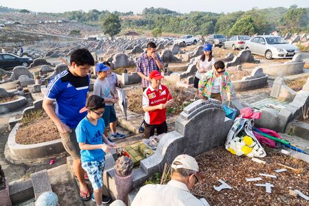 KUALA LUMPUR, MALAYSIA, April 2, 2016: Chinese descendants cleaning tomb and offering prayers to ancestors during the annual QingMing, or tomb sweeping day at cemetery in Malaysiaのeditorial素材