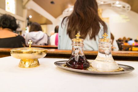 Catholics bread and wine in chalice with de-focused church backgroundの写真素材