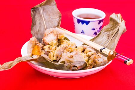 Steamed Chinese rice dumpling or zongzi served on plate with oriental teaの写真素材
