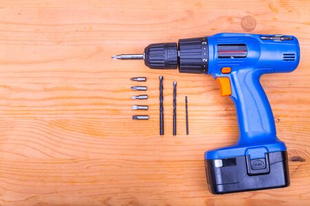 Flatbed of convenient cordless drill cum screwdriver set with bits on wooden backgroundの写真素材