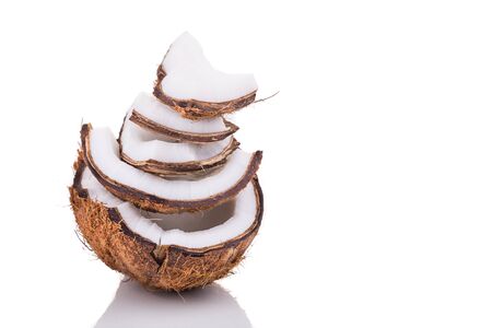 Old brown organic coconut fruit copra broken into pieces and stacked on white backgroundの写真素材