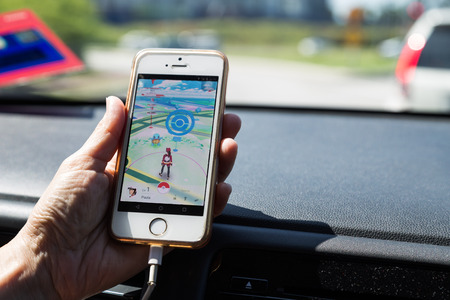 KUALA LUMPUR, MALAYSIA, JULY 24, 2016: An IOS user plays Pokemon Go, a free-to-play augmented reality mobile game developed by Niantic for iOS and Android devices.のeditorial素材