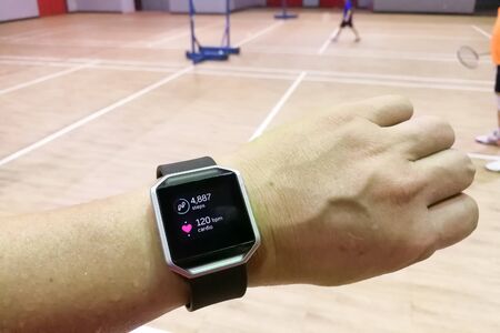 Perspective view of person reading watch with heart tracker during exercise