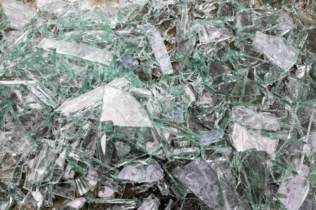Heap of dangerous sharp shattered pieces broken glass on ground