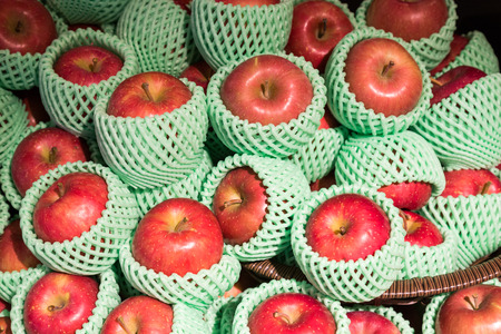 Heap of organic juicy apple with protective foam mesh on retail shelfの写真素材