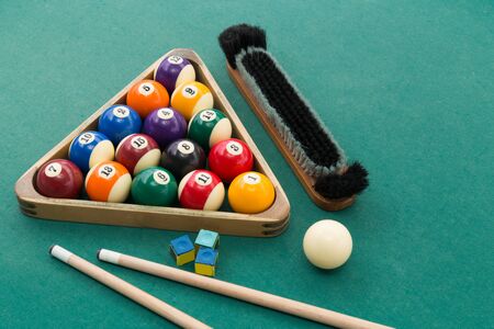 Snooker billards pool balls in triangle, chalk, cue, extender stick and brush on green table
