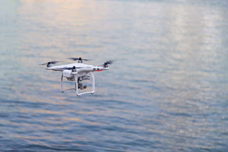 Closeup on drone surveillance flying over river backgroundの写真素材