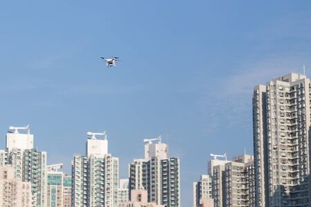 Drone flying doing surveillance take aerial photographs over cityscape