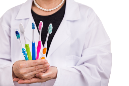 Dentist holding toothbrushes with different head and bristle design for various oral needsの写真素材
