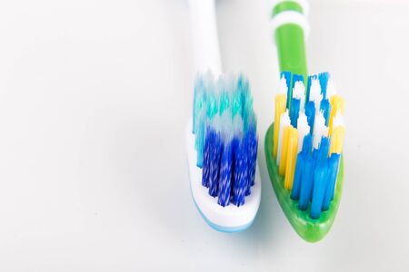 Comparison of toothbrush with  round tip bristle and tapered bristle on white background