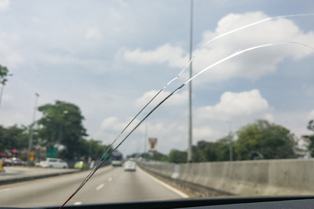 Perspective view of cracked car windscreen or windshield from inside vehicle while drivingの写真素材