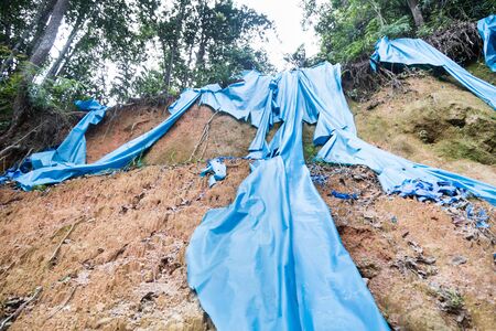 Soil erosion at tropical hilly terrain due to rain and storm. Dangerous to motoristの写真素材