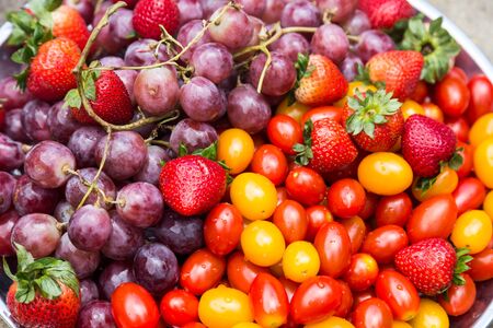 Close-up on fresh and sweet organic grapes, strawberries, cherry tomatoes, rich in vitamin C and antioxidantの写真素材