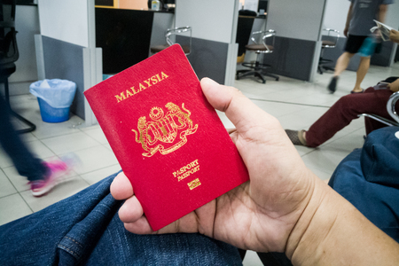Person holding Malaysia international passport.の写真素材