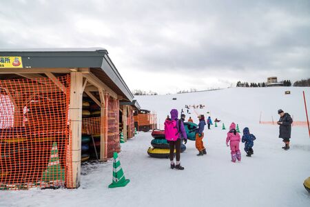 Sapporo, Japan, January 28, 2018: Takino  Suzuran Hillside Park offers family fun activities during winter. Featured here kids having fun in snow boarding on slop.のeditorial素材
