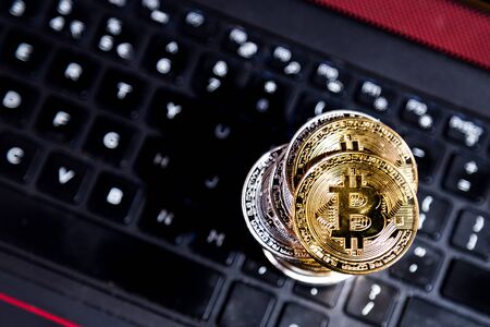 Stack of conceptual cryptocurrency bitcoin on computer lighted keyboard