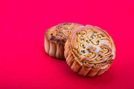 Close-up on mooncake, pastries for Chinese mid-autumn festive in red backgroundの写真素材