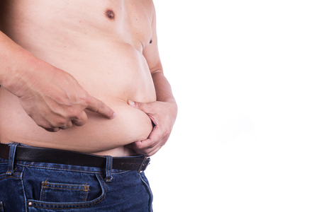 Man pinching own unhealthy big belly with visceral or subcutaneous fats. Pose health risk.の写真素材