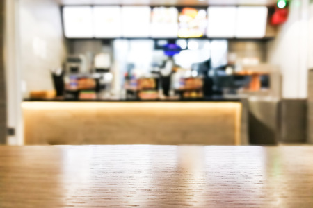 Table foreground with blurred fast food counter background as graphic resources