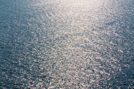 Blue ocean sea with glowing reflection from sky as backgroundの写真素材