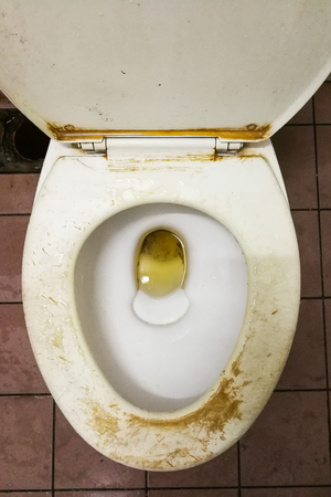 Dirty smelly public toilet bowl with stain and limescaleの写真素材