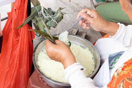 Person preparing Chinese steamed dumpling or bak chang, stuffed glutinous rice with meat, traditional and  popular cuisineの写真素材