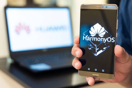 KUALA LUMPUR, MALAYSIA, August, 11, 2019: Huawei officially announced its new operating system, HarmonyOS. Illustrative of developer developing HarmonyOS on computer and smartphone screen.のeditorial素材