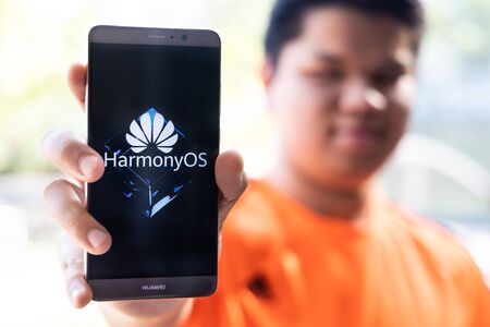 KUALA LUMPUR, MALAYSIA, August, 11, 2019: Huawei officially announced its new operating system, HarmonyOS. Illustrative of person holding Huawei smart phone with HarmonyOS on screen.のeditorial素材