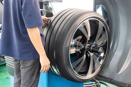Series of worker balancing tire with wheel balancing machinery in workshop