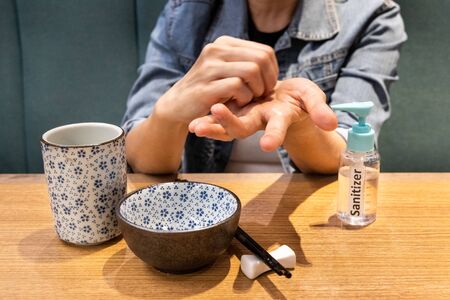 Series of person cleaning hands after spraying with disinfectant sanitizer before meal at dining...