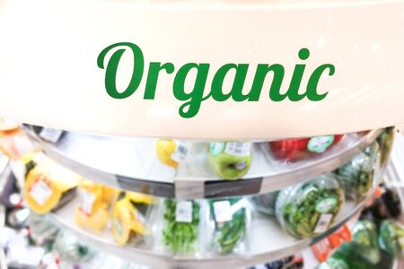Organic word signage at supermarket vegetable and fruits refrigerated aisle sectionの写真素材