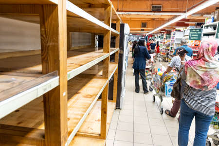 KUALA LUMPUR, MALAYSIA, MARCH 16, 2020: Panic buying among shoppers at supermarkets resulting empty...