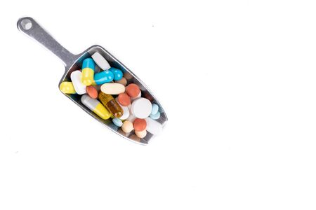 Healthcare concept on ladle with overhead view on scoop of various medicine tablet, caplets, pills, capsule on white backgroundの写真素材