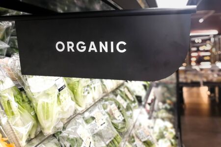Closeup of organic produce vegetable fruits aisle with signage word in supermarketの写真素材