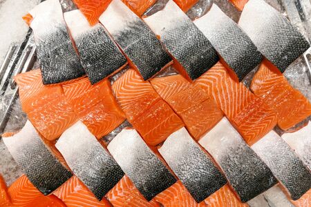Blocks of fresh raw salmon fillet display for sale in supermarketの写真素材